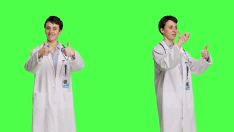 Cheerful-medic-doing-thumbs-up-symbol-against-greenscreen-backdrop